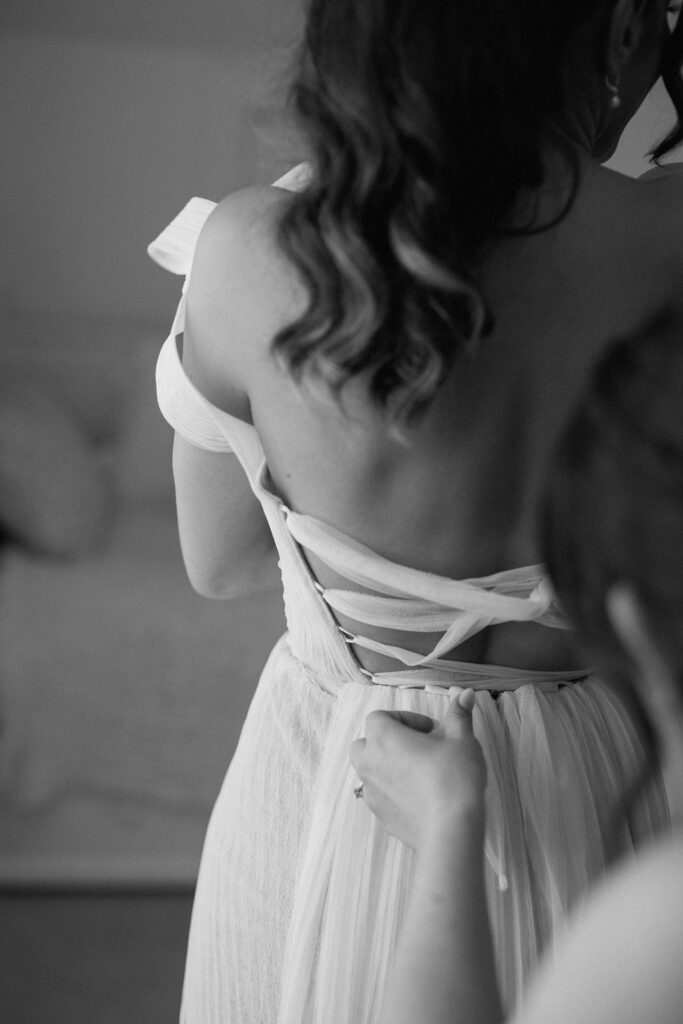 Bride getting ready with natural light pouring into the room before her Northern California sailboat wedding