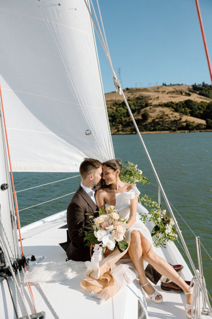 Bride wearing a flowing wedding gown in ocean breeze during a Northern California sailboat wedding