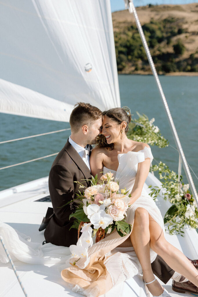 Bride wearing a flowing wedding gown in ocean breeze during a Northern California sailboat wedding