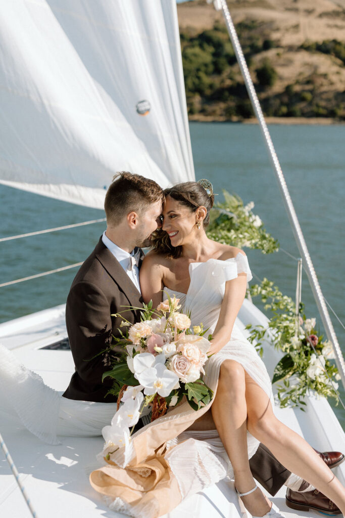 Bride wearing a flowing wedding gown in ocean breeze during a Northern California sailboat wedding