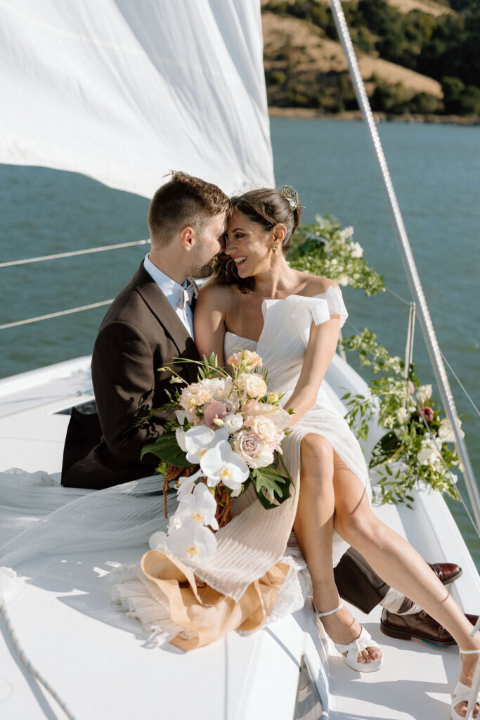 Bride wearing a flowing wedding gown in ocean breeze during a Northern California sailboat wedding