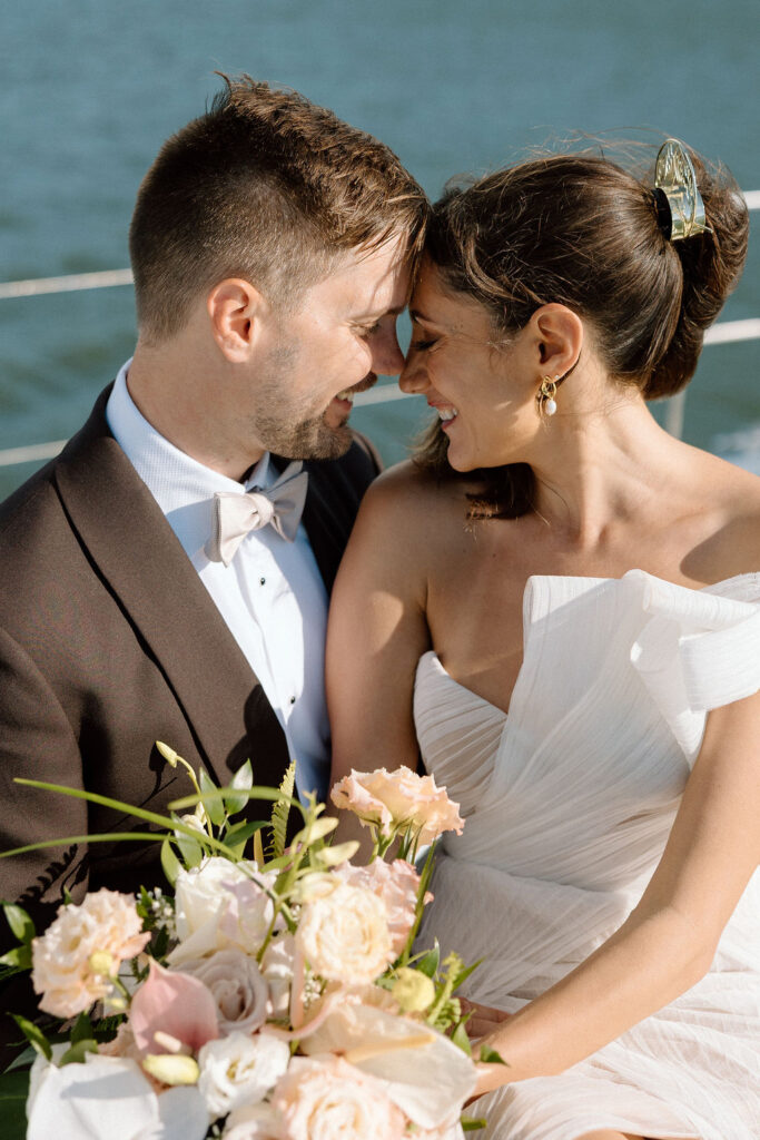Bride wearing a flowing wedding gown in ocean breeze during a Northern California sailboat wedding