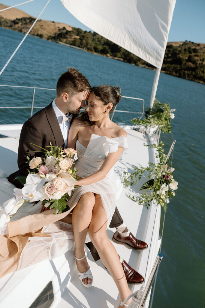 Bride wearing a flowing wedding gown in ocean breeze during a Northern California sailboat wedding