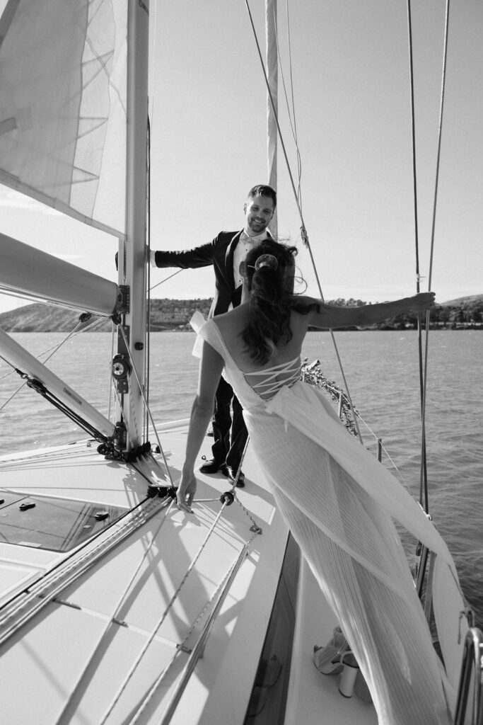 Bride wearing a flowing wedding gown in ocean breeze during a Northern California sailboat wedding