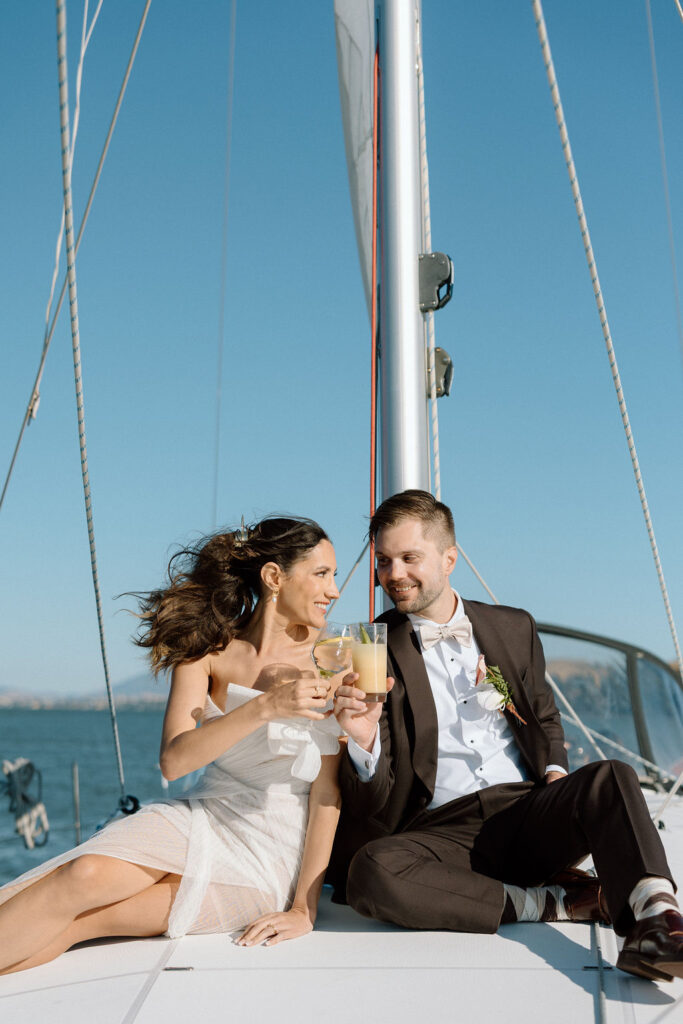 Bride wearing a flowing wedding gown in ocean breeze during a Northern California sailboat wedding