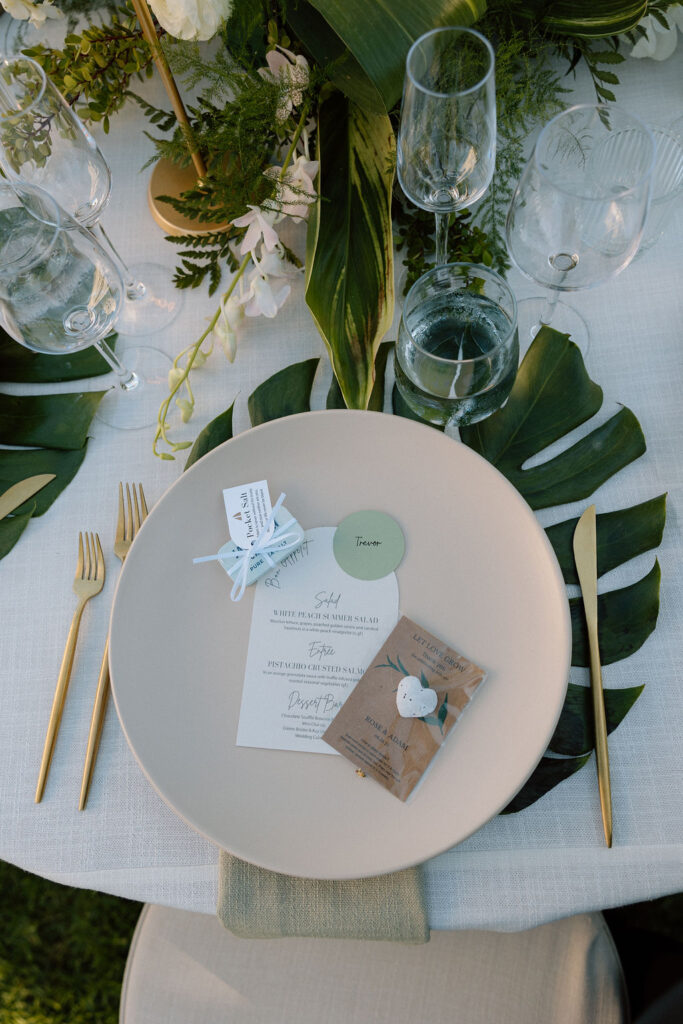 Outdoor wedding reception at Glen Cove Marina with serpentine head table, lush florals, and golden sunset light