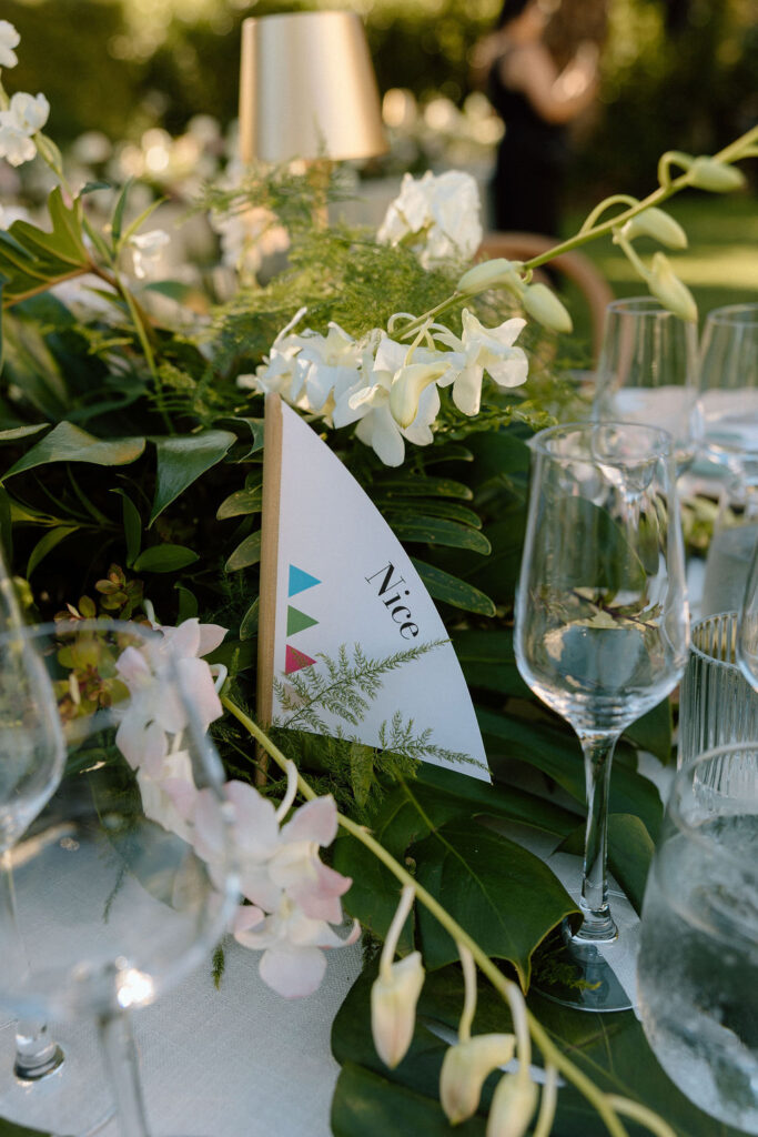 Outdoor wedding reception at Glen Cove Marina with serpentine head table, lush florals, and golden sunset light