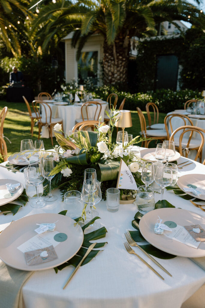 Outdoor wedding reception at Glen Cove Marina with serpentine head table, lush florals, and golden sunset light