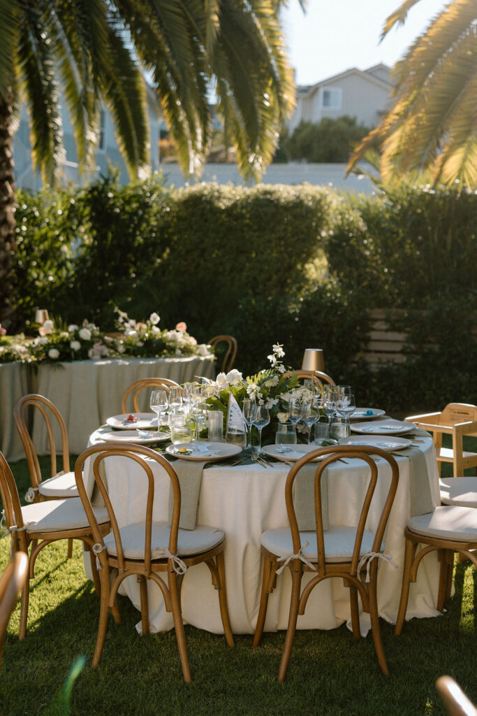 Outdoor wedding reception at Glen Cove Marina with serpentine head table, lush florals, and golden sunset light