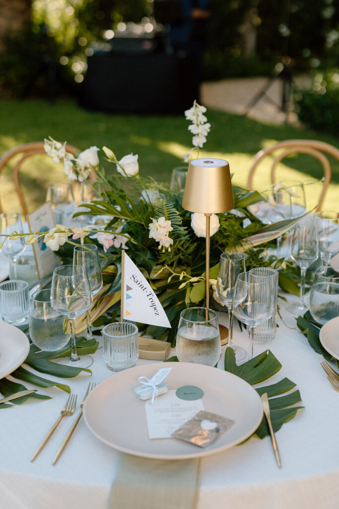 Outdoor wedding reception at Glen Cove Marina with serpentine head table, lush florals, and golden sunset light