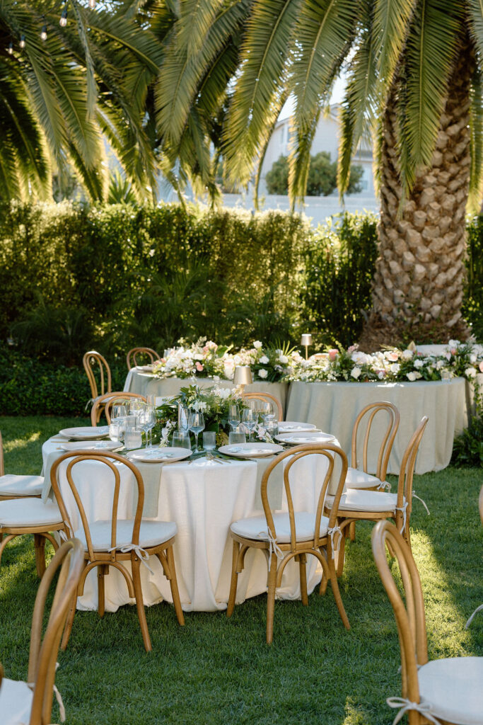 Outdoor wedding reception at Glen Cove Marina with serpentine head table, lush florals, and golden sunset light