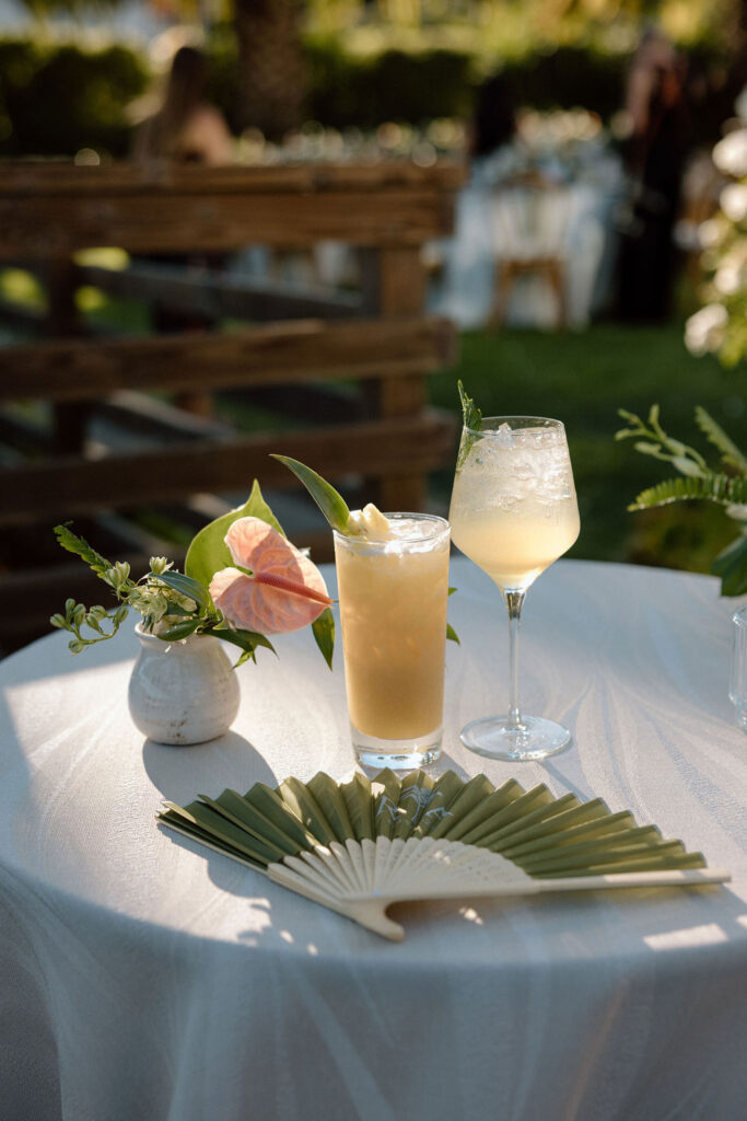 Outdoor wedding reception at Glen Cove Marina with serpentine head table, lush florals, and golden sunset light