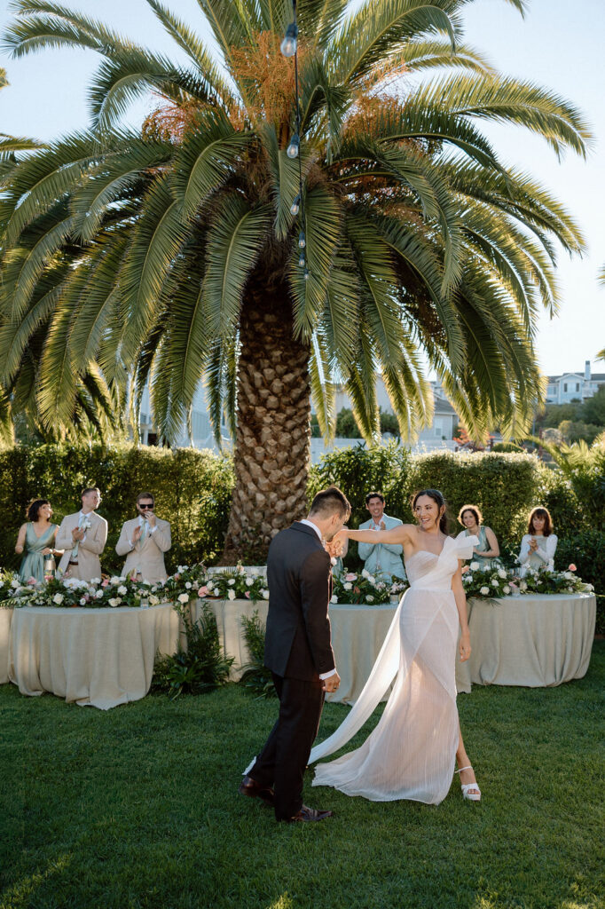 Golden hour reception beneath palm trees at a Northern California waterfront wedding