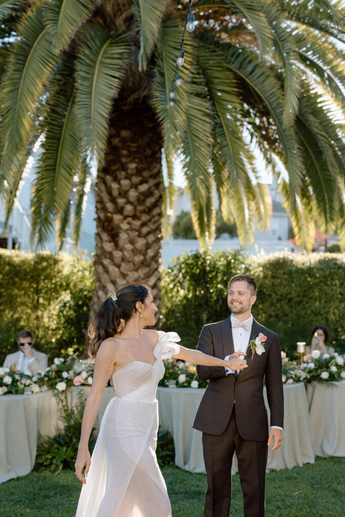 Golden hour reception beneath palm trees at a Northern California waterfront wedding