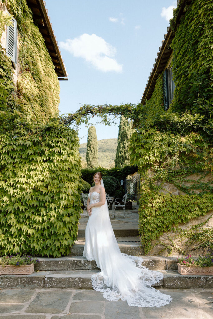 Bride and groom walking through the gardens of Villa di Piazzano in Tuscany, surrounded by cypress trees and rolling hills during an intimate destination wedding.