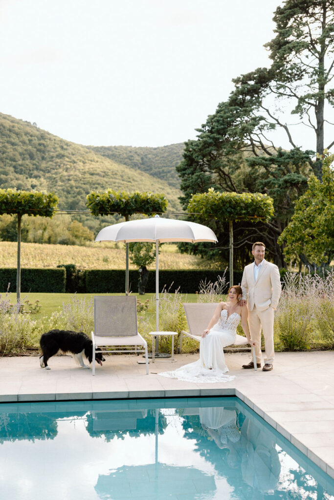 Bride and groom laughing with the villa dog during portraits at Villa di Piazzano, adding a playful and personal touch to their destination wedding.
