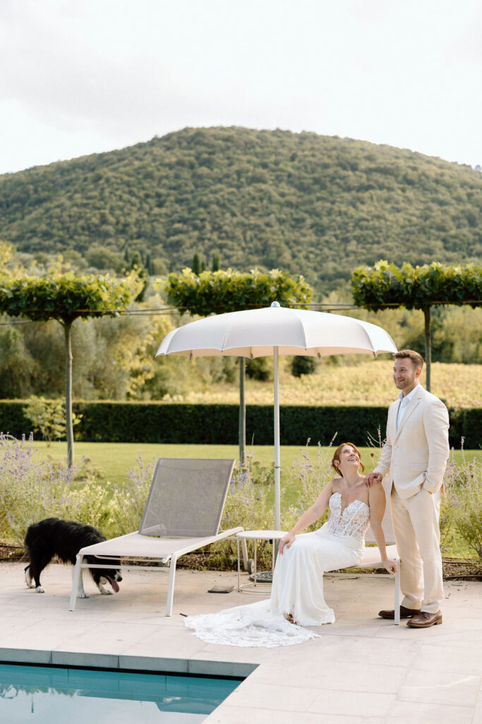 Bride and groom laughing with the villa dog during portraits at Villa di Piazzano, adding a playful and personal touch to their destination wedding.