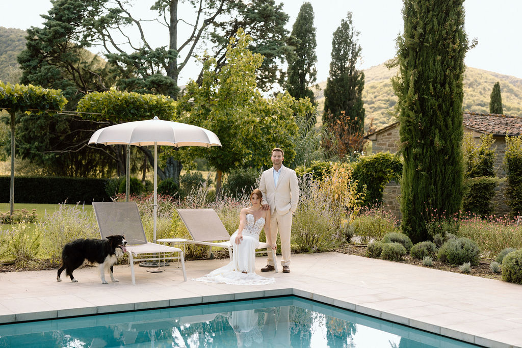 Bride and groom laughing with the villa dog during portraits at Villa di Piazzano, adding a playful and personal touch to their destination wedding.