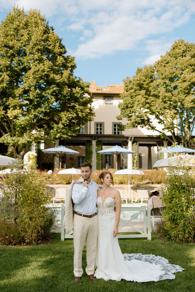 Bride and groom walking through the gardens of Villa di Piazzano in Tuscany, surrounded by cypress trees and rolling hills during an intimate destination wedding.