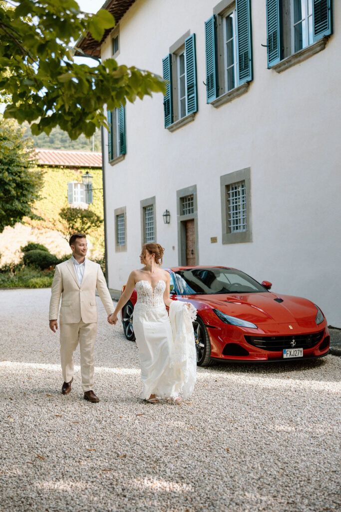 Bride and groom walking through the gardens of Villa di Piazzano in Tuscany, surrounded by cypress trees and rolling hills during an intimate destination wedding.