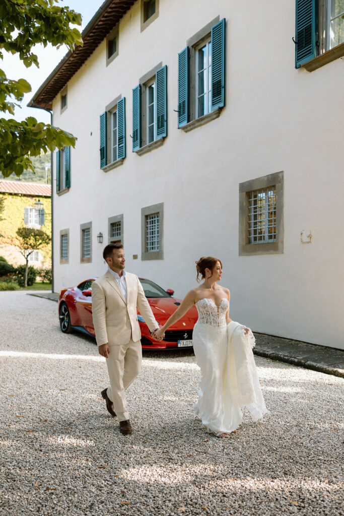 Bride and groom walking through the gardens of Villa di Piazzano in Tuscany, surrounded by cypress trees and rolling hills during an intimate destination wedding.