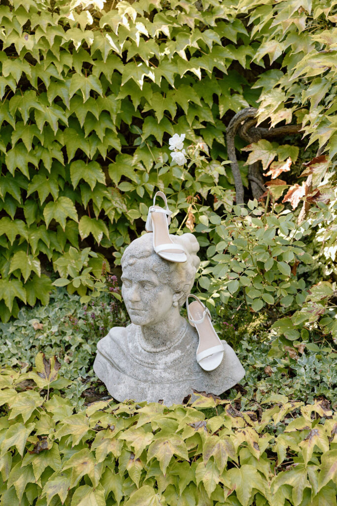 Bride wearing a lace wedding gown with corseted bodice and cathedral veil while getting ready in an antique-filled suite at Villa di Piazzano.