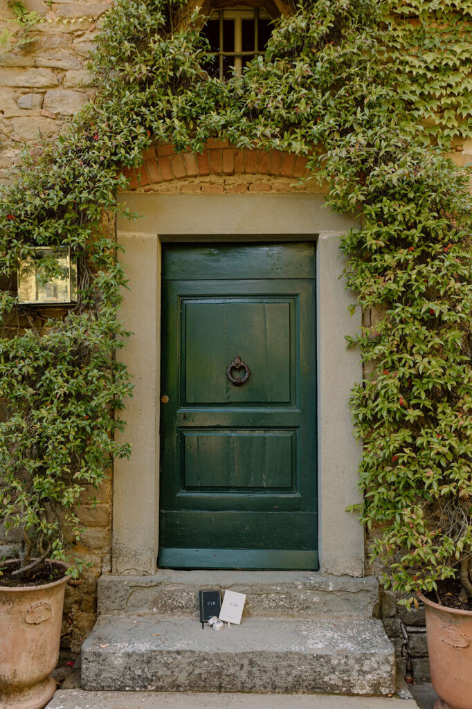 Bride wearing a lace wedding gown with corseted bodice and cathedral veil while getting ready in an antique-filled suite at Villa di Piazzano.