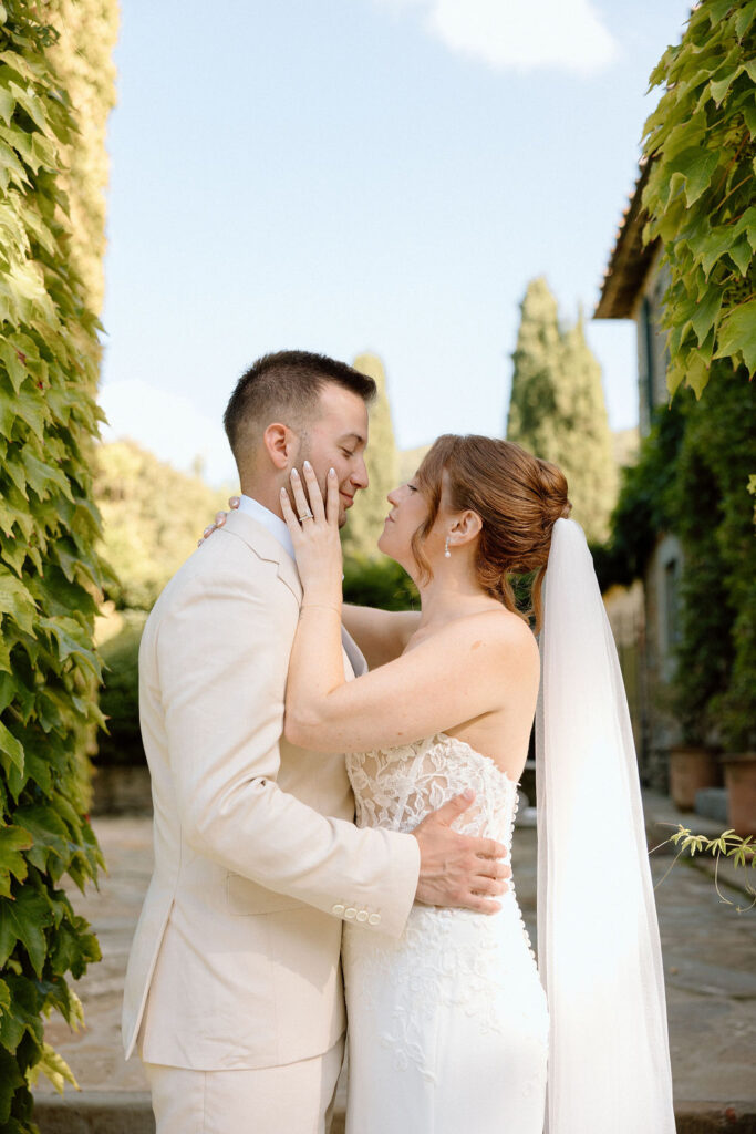 Bride and groom walking through the gardens of Villa di Piazzano in Tuscany, surrounded by cypress trees and rolling hills during an intimate destination wedding.