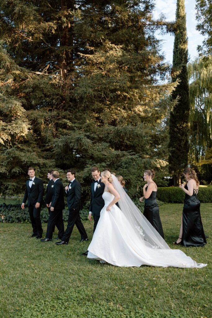 bride and groom walking casually with wedding party captured candidly by california wedding photographer