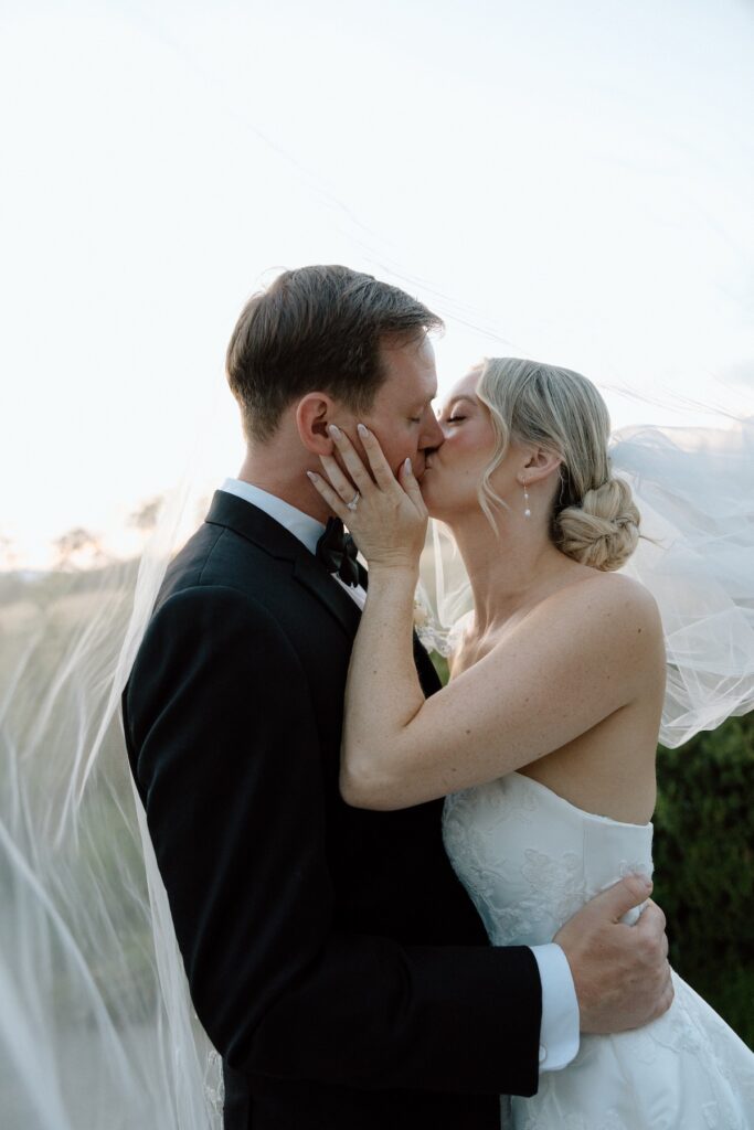 bride and groom pose romantically under the brides veil during sunset on wedding day at california wedding 
