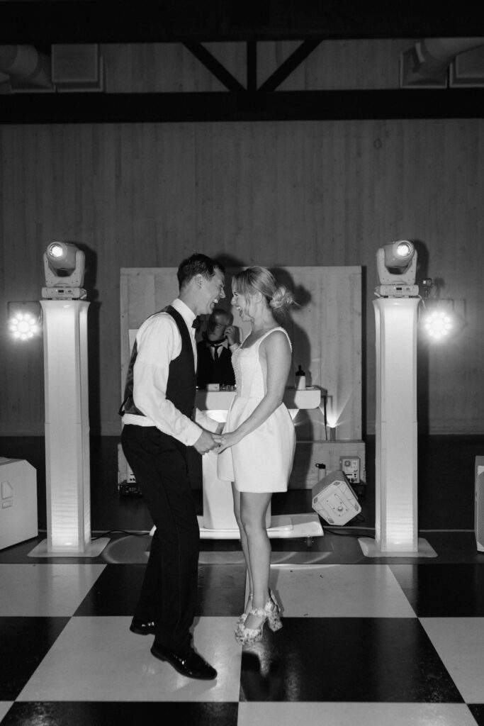 Bride and groom jump and dance excitedly with the dj in the background at their california wedding reception party
