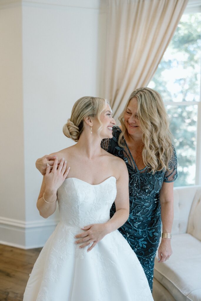 Bride and Mom smiling together after bride gets into wedding dress at Park Winters on wedding day