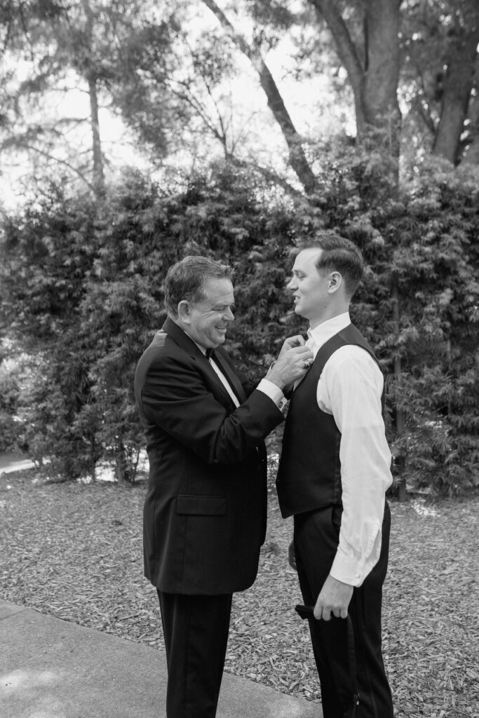 Dad ties tie for Groom on wedding day at Park Winters, both are smiling