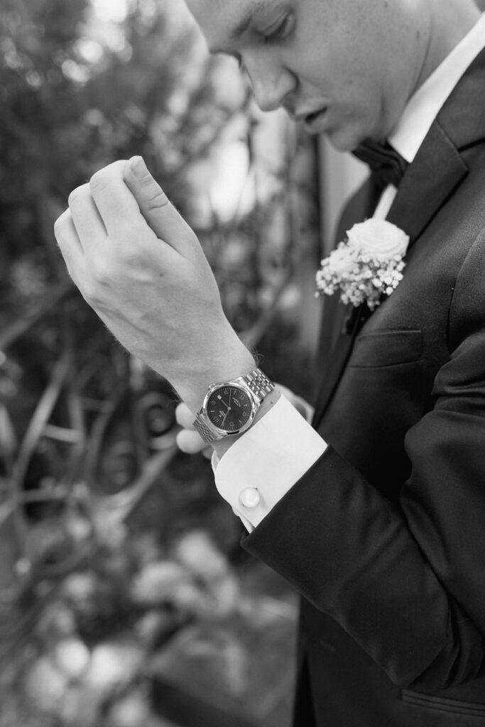 Groom adjusts watch that was a gift from his bride on wedding day at Park Winters