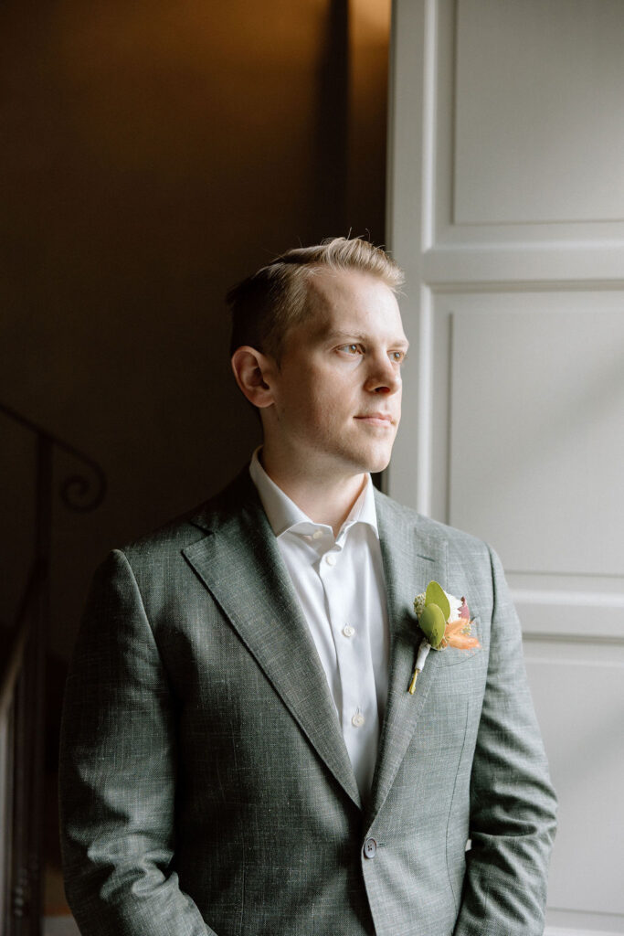 Groom getting ready for his Tuscan elopement, captured in a quiet moment inside a countryside villa in Italy