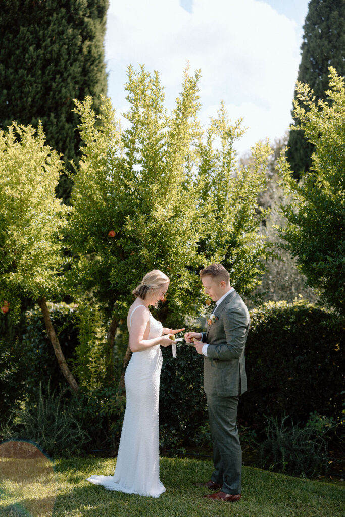 Couple exchanging vows during an intimate Italian elopement ceremony set against the rolling hills of Tuscany.