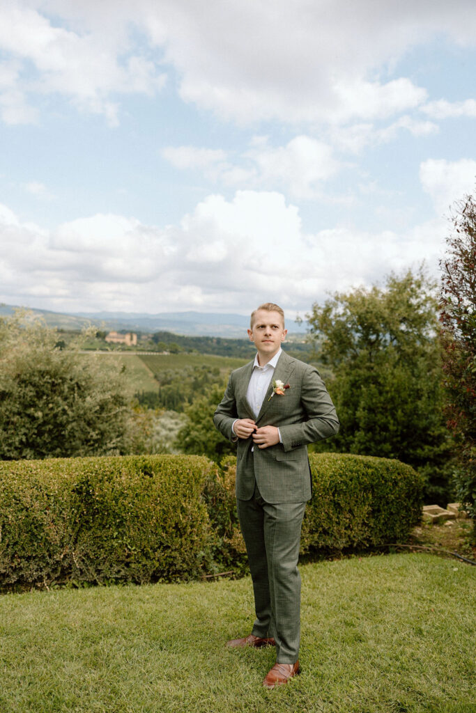 Groom finishing his wedding attire while getting ready for a private elopement in the Tuscan countryside.