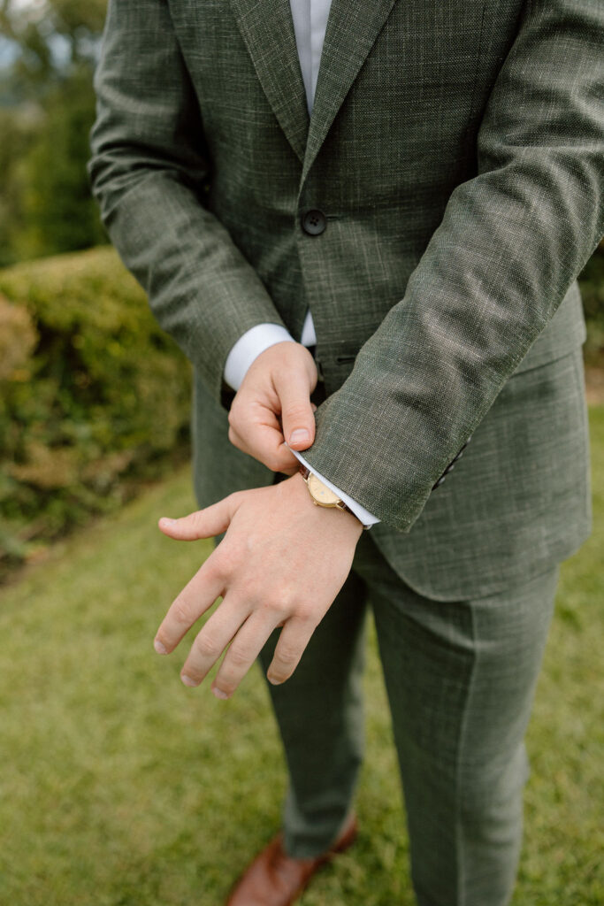 Groom finishing his wedding attire while getting ready for a private elopement in the Tuscan countryside.