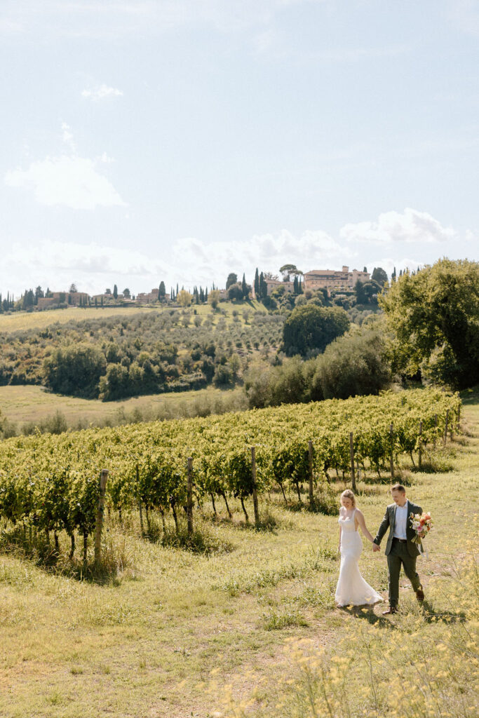 Joyous couple exploring the Tuscan hills and vineyards at COMO Castello Del Nero during their intimate Italian elopement.