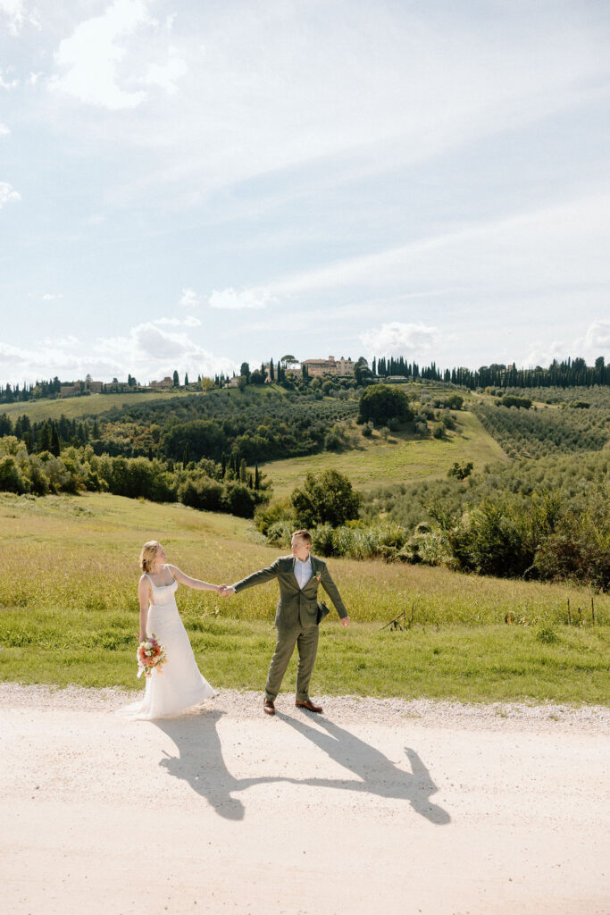 Joyous couple exploring the Tuscan hills and vineyards at COMO Castello Del Nero during their intimate Italian elopement.