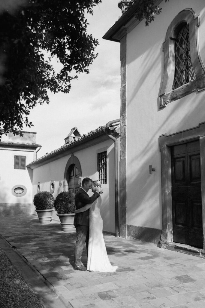 Bride and groom exploring the grounds of a Tuscan villa after their ceremony, embracing the quiet elegance of an Italian wedding.
