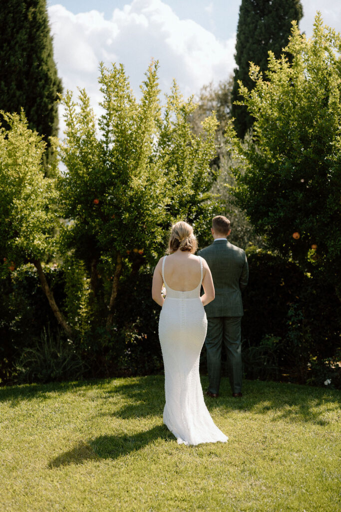 Bride and groom standing together during their private elopement ceremony in Tuscany, framed by soft light and the Italian landscape.