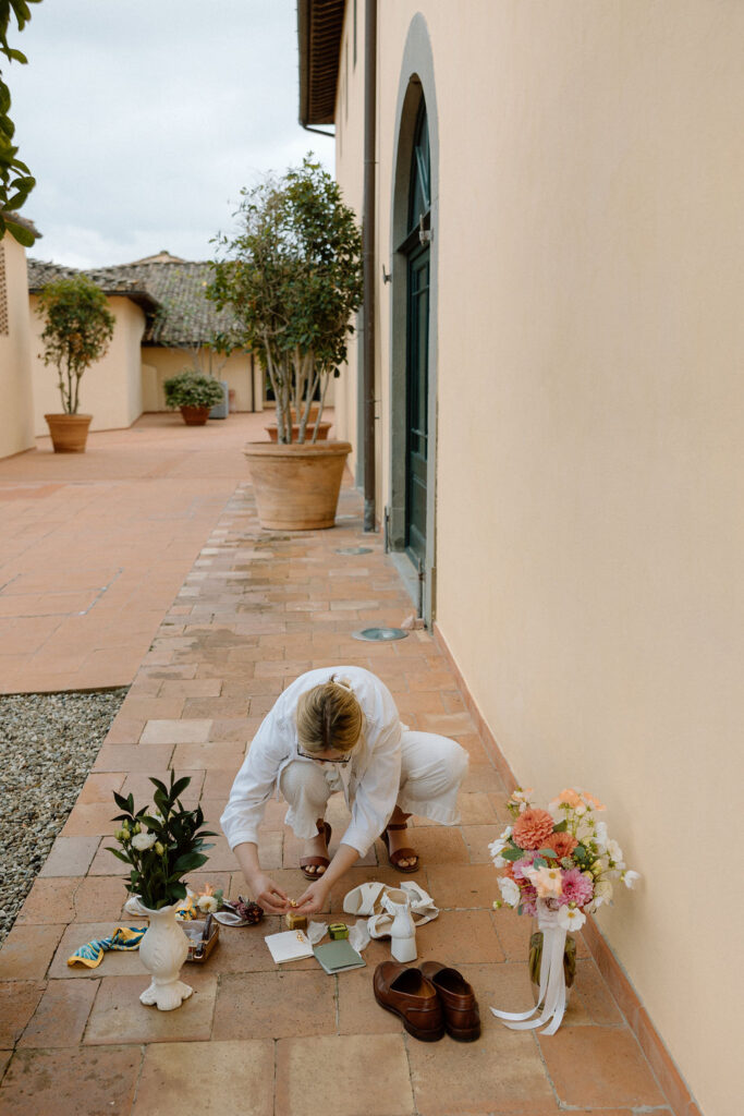 A joyous couple from the United States Elope in the hills of Tuscany at COMO Castello Del Nero and the bride is also a stationary designer and help set up her own flat lay